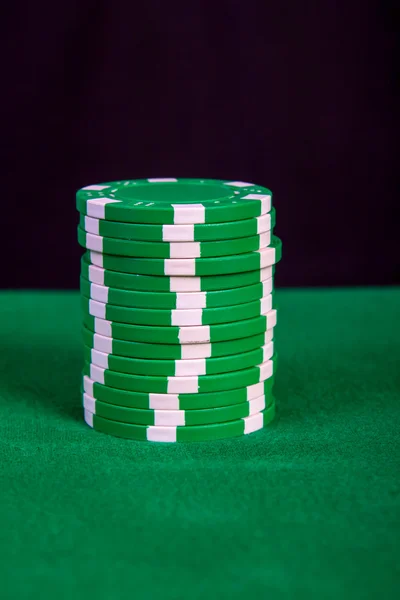Pilha de chips verdes em uma mesa de jogo verde — Fotografia de Stock