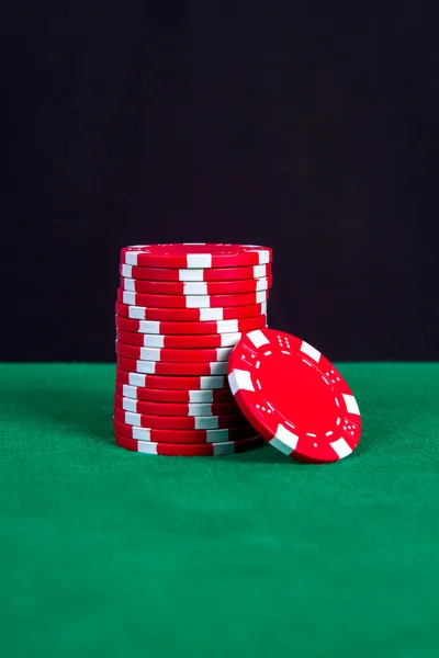 Stack of red chips on a green playing table — Stock Photo, Image