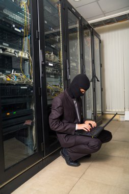 siyah maskeli soyguncu sunucu odası dizüstü bilgisayarda veri indirmek kesmek