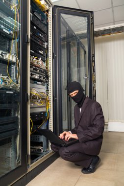 siyah maskeli soyguncu sunucu odası dizüstü bilgisayarda veri indirmek kesmek