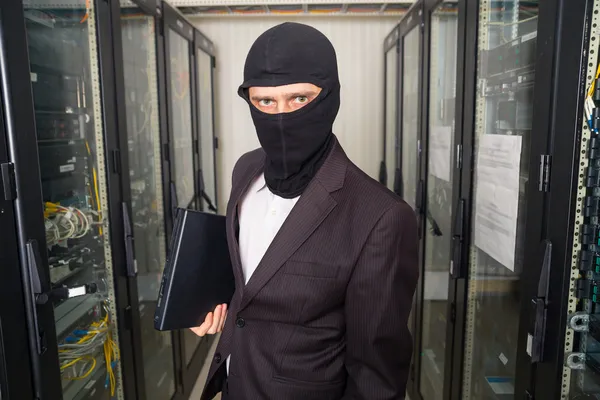 siyah maskeli soyguncu sunucu odası dizüstü bilgisayarda veri indirmek kesmek