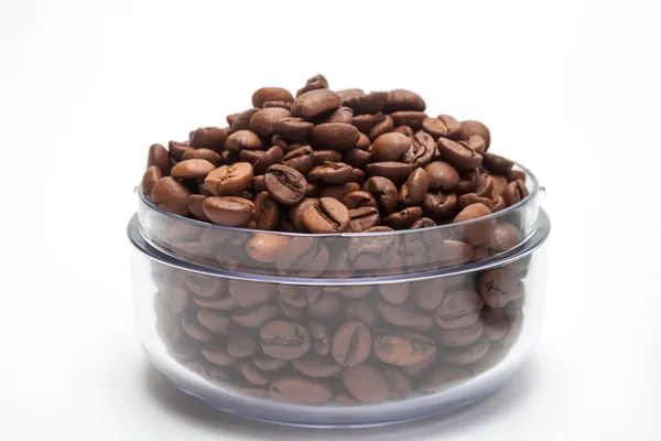 Transparent cup with coffee beans isolated — Stock Photo, Image