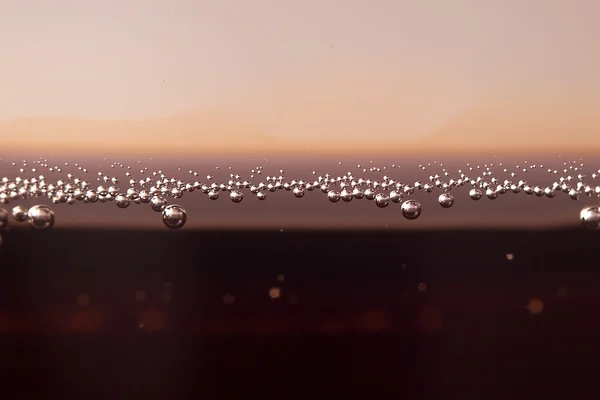 Macro black bubbles  on the glass wall of cola — Stock Photo, Image