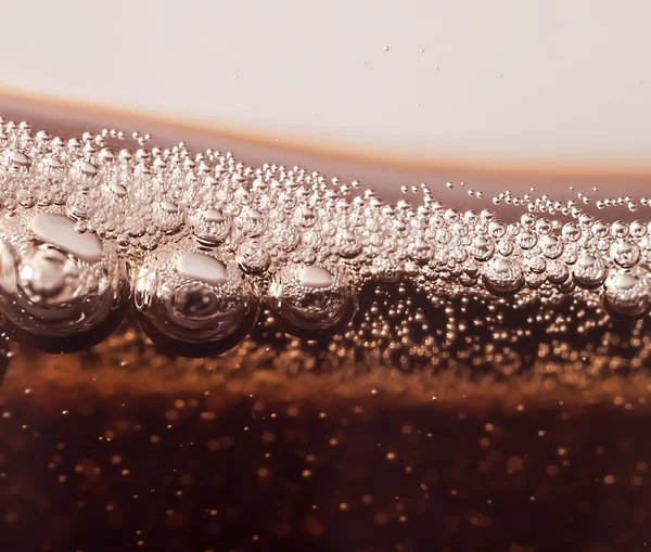 Macro black bubbles o n the glass wall of cola — Stock Photo, Image