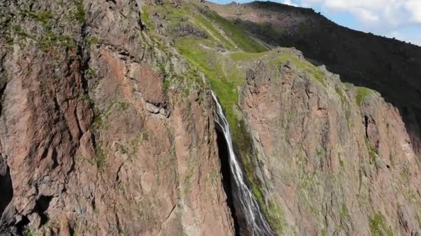 Increíble cascada entre montañas escarpadas y altas rocosas, vista aérea — Vídeo de stock