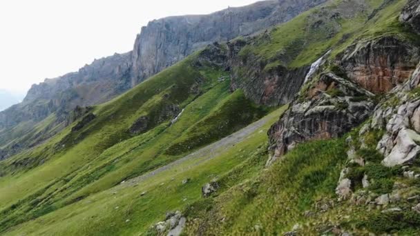 上と滝の上に岩の厚い草と大きな丘の中腹 — ストック動画