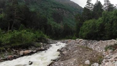 Dar nehir, keskin kayalıkların arasından dağlara doğru akar.