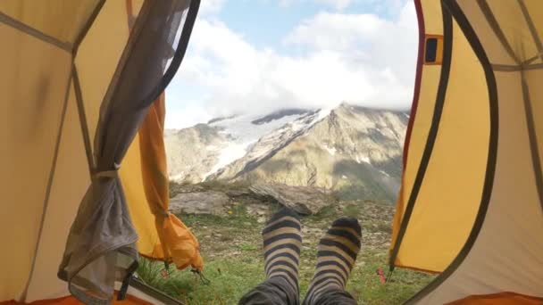 Person lies in yellow tent and moves feet in colored socks — Stock Video