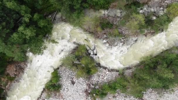 바위투성이의 가파른 언덕 들 사이로 굽이쳐 흐르는 거친 강 — 비디오