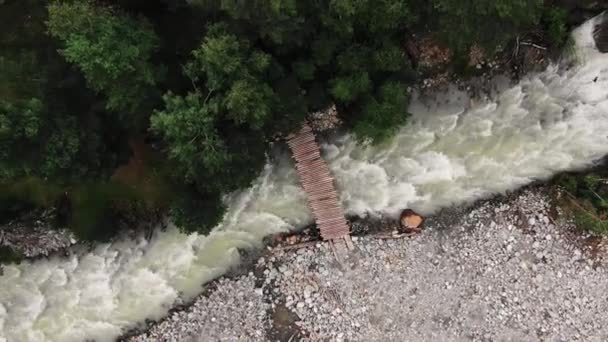 Jembatan kayu di atas sungai berjalan antara hutan dan batu — Stok Video