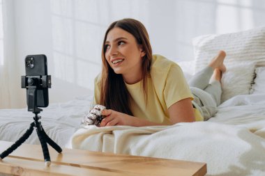 Biyonik protez kollu bir kadın blogcu bir internet yayınını yönetiyor ya da bir konuyu kaydediyor ya da yatakta uzanırken arkadaşlarıyla görüntülü iletişim kuruyor.