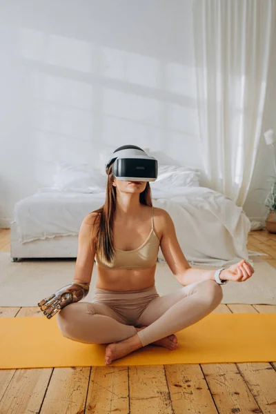 Woman with bionic prosthesis and VR headset in sunny room