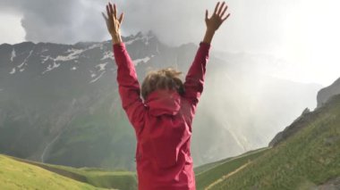 Bayan zıplar ve el sallar tepenin yamacında