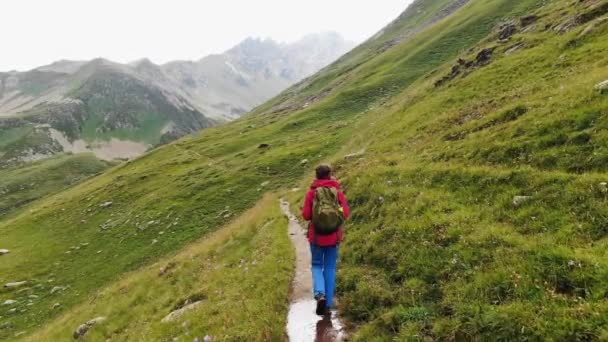 Femme marche sur le sentier à flanc de colline contre les montagnes paysage — Video