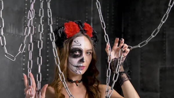 Lady model z makijażem czaszki pozuje w studio z łańcuchami — Zdjęcie stockowe