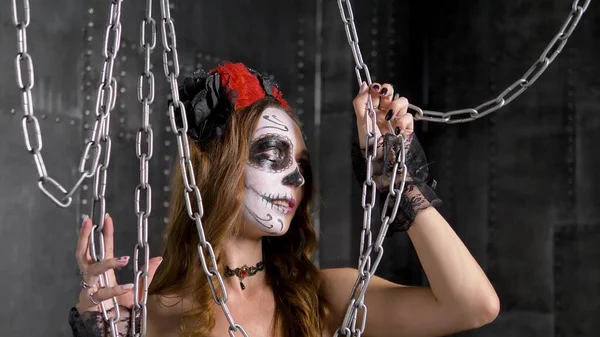 Lady model met schedel make-up poses in studio met kettingen — Stockfoto