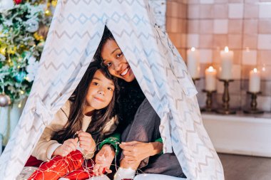 Kız ve siyah anne battaniye kulübesinde saklanıyor.