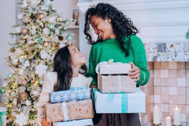 Afrika kökenli Amerikalı anne ve kızı Noel hediyelerini tutuyor.
