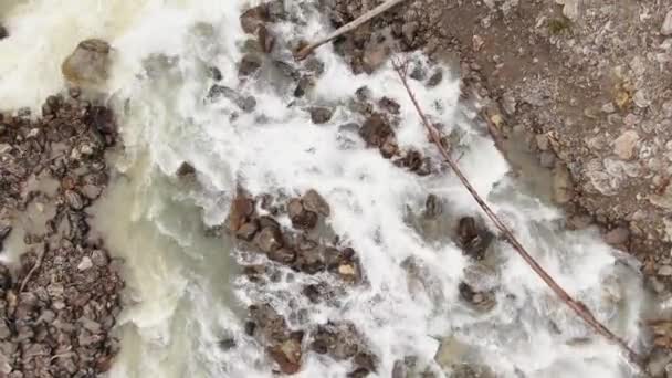 Wąska rzeka z szybkimi strumieniami wody spływa między skałami — Wideo stockowe