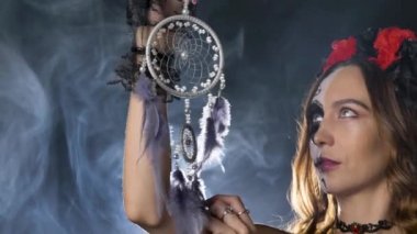 Kafatası makyajlı bayan model, düş kapanı ile duman içinde poz veriyor.