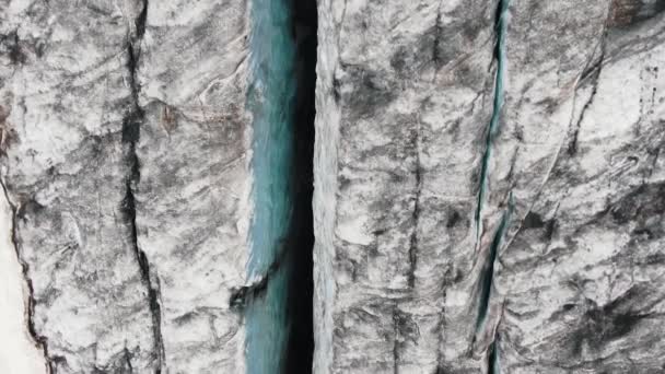 Wysokie klify pokryte śniegiem i szczeliny w czarnych skałach — Wideo stockowe