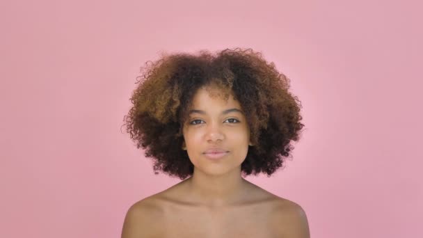 Portrét roztomilé Afroameričanky dívající se do kamery a usmívající se na růžovém pozadí — Stock video