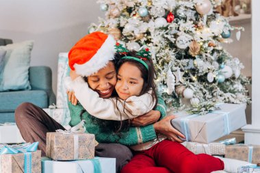 Noel 'de kız ve Afrikalı Amerikalı anne kucaklaşması