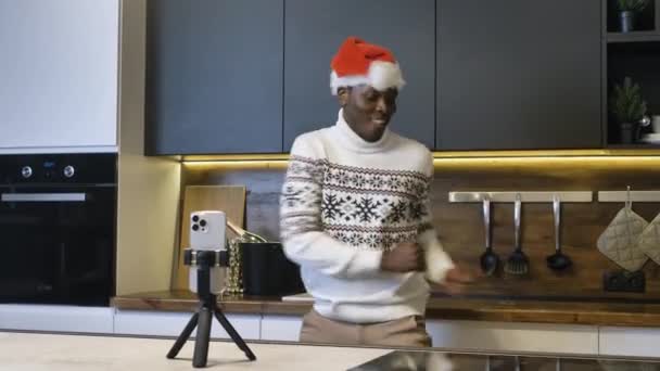 Młody czarny człowiek tańczy filmowanie z telefon w kuchnia — Wideo stockowe