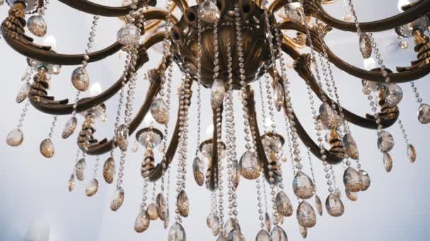 Chandelier with glass decorations hangs illuminating room — Stock Video