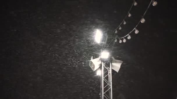 Parlak spot ışıklarının arka planında şiddetli kar yağışı — Stok video