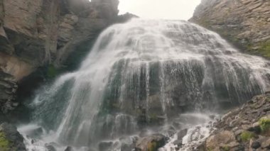 Köpüklü suları olan şelale kayalar boyunca akıyor.