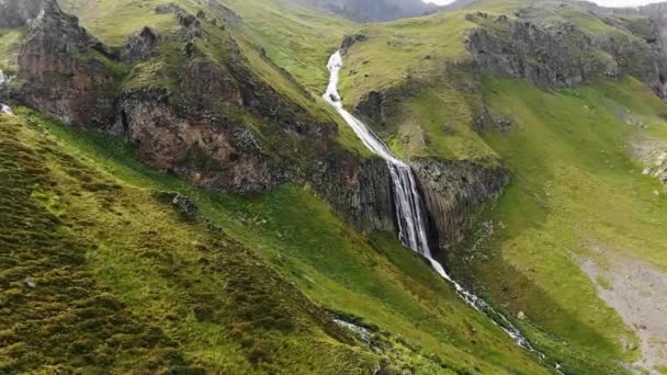 Großer Hang mit dickem Gras oben und Wasserfall — Stockvideo