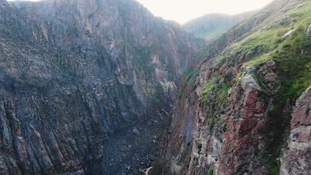 Μεγάλες καφέ απότομη βράχια με γρασίδι στην κορυφή και το ποτάμι στο φαράγγι — Αρχείο Βίντεο