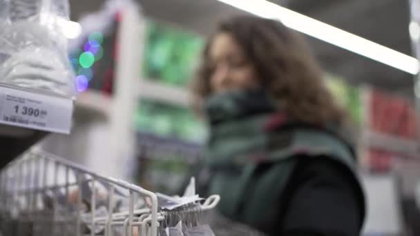 Femme aux cheveux bouclés choisit des ornements pour l'arbre de Noël — Video