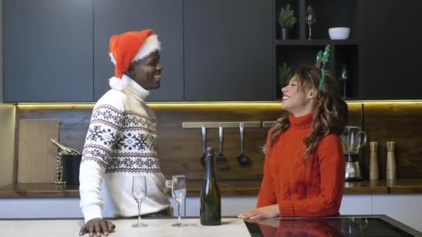 Black man and woman talk drinking champagne in kitchen — Αρχείο Βίντεο