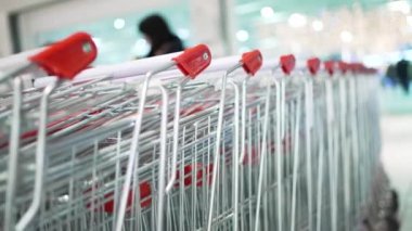 Row of shopping trolleys standing near trade mall entrance