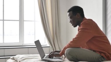 African-American man screams with happiness near laptop