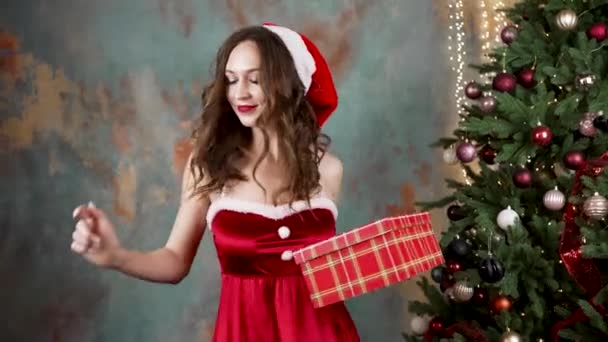 Smiling woman holds gift box and dances in festive clothes — Video Stock