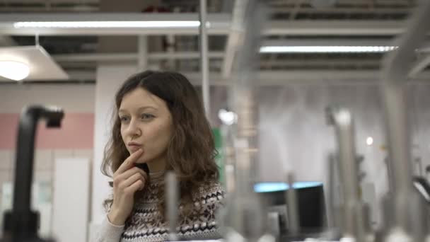 Brunette woman chooses new faucet for apartment renovation — Stock videók