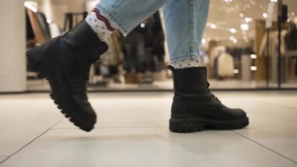 Woman in boots walks near clothes shops in shopping centre — 비디오