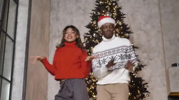 Αφροαμερικάνος άντρας και γυναίκα χορεύουν ενάντια στο χριστουγεννιάτικο δέντρο — Αρχείο Βίντεο