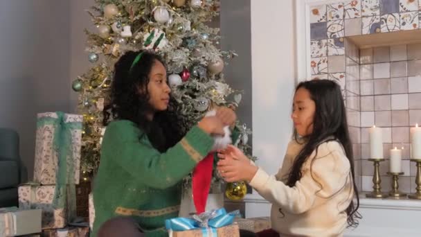 Mother and daughter put Christmas hats on each other — Stockvideo