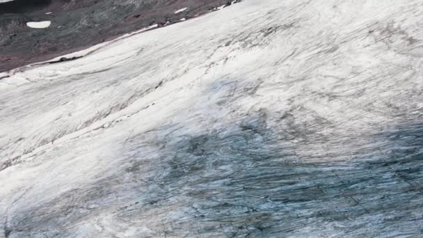 Altos acantilados cubiertos de nieve y grietas en rocas negras — Vídeos de Stock