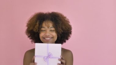 Amazed African American lady holds present box smiling