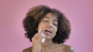 Relaxed young woman with short curly hair massages neck