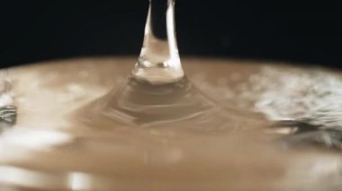 A drop of water falls into the water in slow motion
