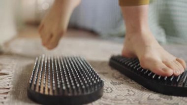 Athletic woman in yellow sport-suit steps on yoga equipment
