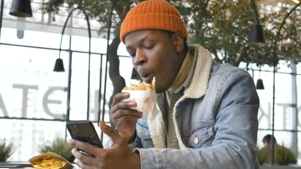 Concentrated businessman in jacket eats delicious burger — Vídeo de Stock