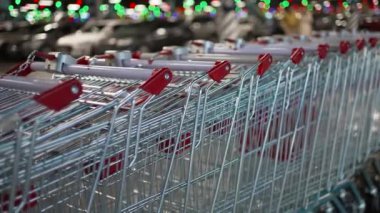 Shopping carts stand in an even row near the car park in the mall