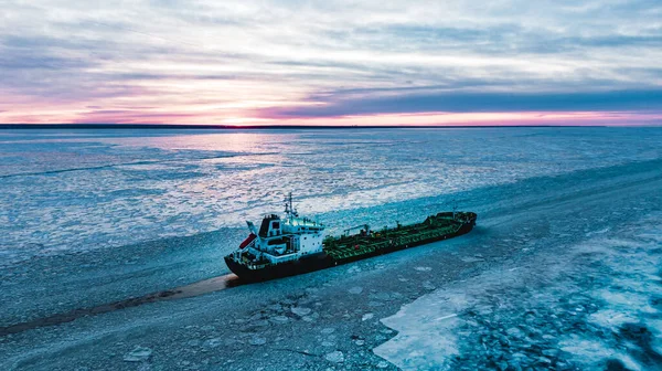 Duży cysterna z paliwem jest w środku lodu w morzu o zachodzie słońca — Zdjęcie stockowe